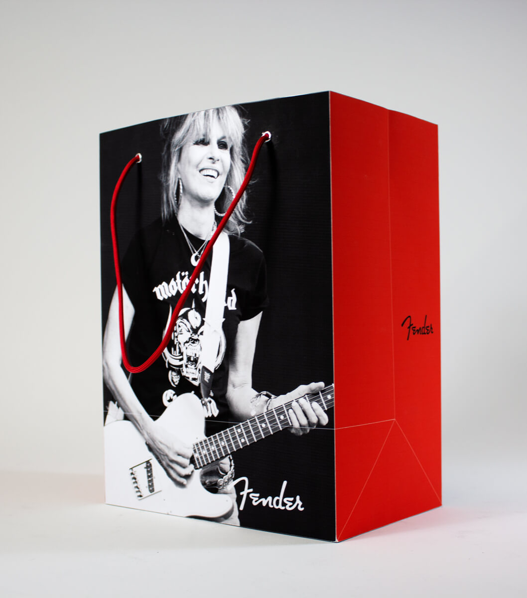 Closeup of a red bag with a photo of Chrissie Hynde playing guitar and the Fender logo.