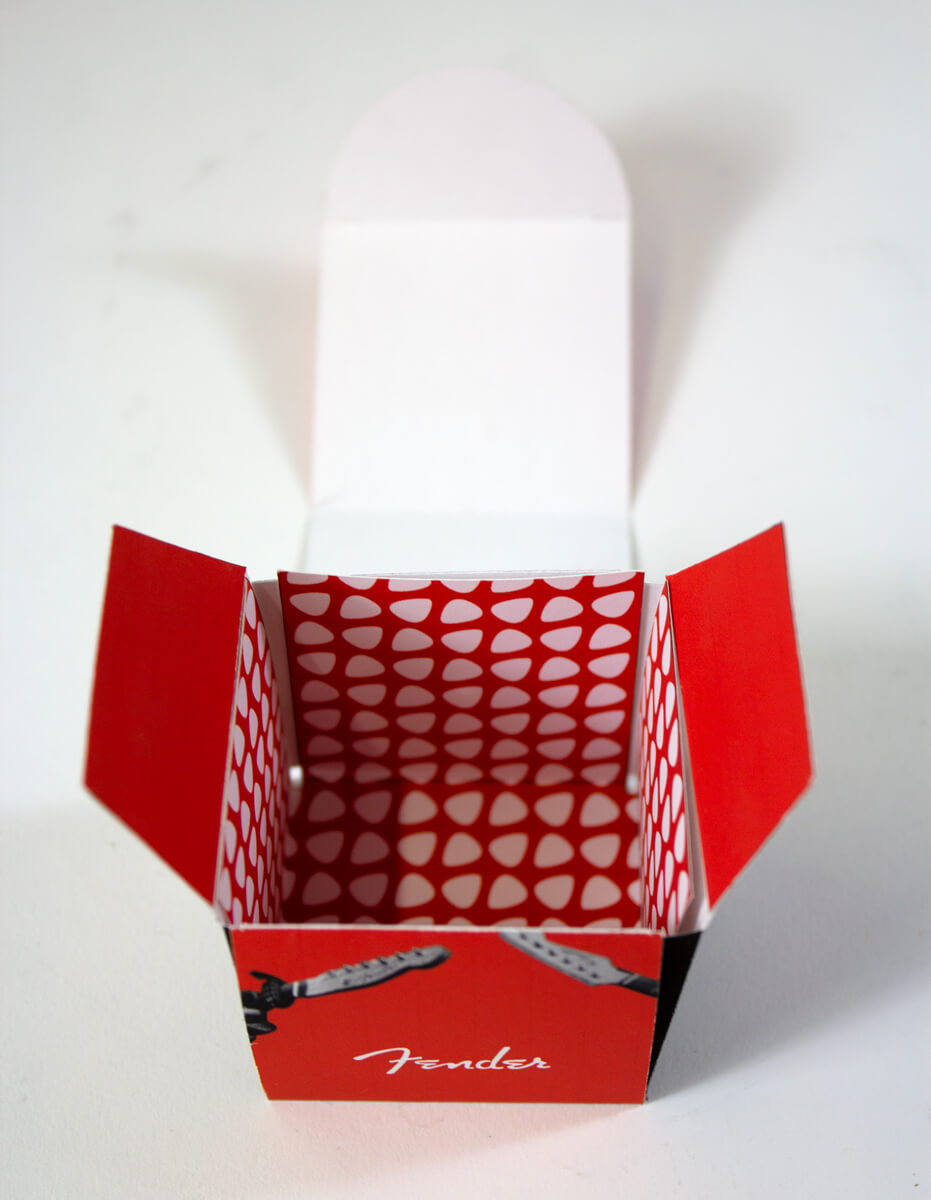 Closeup of a small box with a pattern of white picks on a red background.